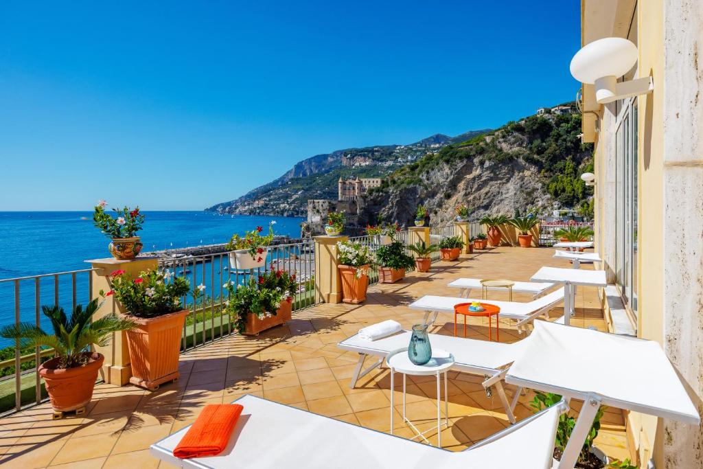 A shot of Amalfi Coast from the rooftop of Residence Panoramic, a budget hotel in Maiori with sun lounges and potted plants.
